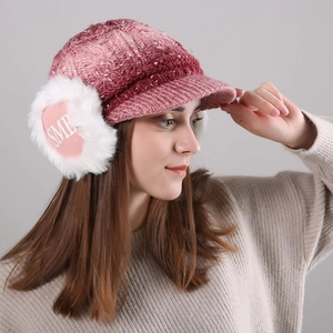 Detail of pink gradient knitted earflap hat with soft white faux fur and SME logo