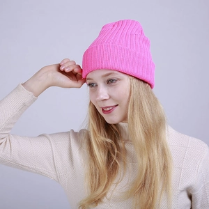 Detailed close-up of ribbed texture on a vibrant neon pink knitted winter beanie hat