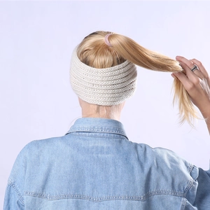 Détail d'un bandeau en maille épaisse blanc crème porté par un mannequin en queue de cheval