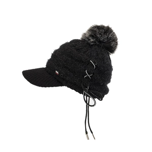 Detailansicht der schwarzen Strickmütze mit Kunstpelz-Bommel und Schnürung aus Silberringen