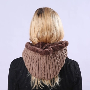 Detail view of the plush faux fur lining and chunky cable knit texture on the brown hood