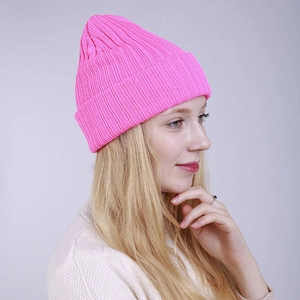 Detail of the bright pink ribbed knit beanie showing thick texture and folded cuff