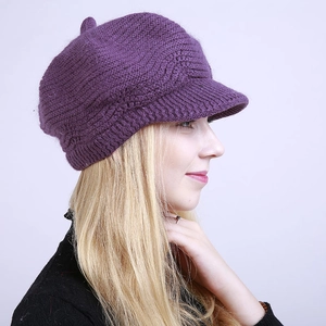 Detail of the purple knitted newsboy cap showing its thick wavy texture and short brim
