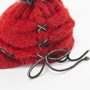Rote Strickmütze mit grauem Pelzbommel und markierten Kreuzschnürungen für Damen im Winter