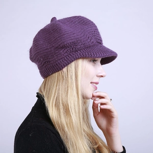 Detail shot of deep purple knitted newsboy cap showing warm wool texture and thick brim