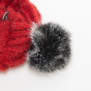 Warme Winterstrickmütze für Damen in Rot mit weichem schwarzen Kunstfell-Bommel-Detail