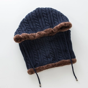 Detail of navy knit winter hat with thick brown fleece lining and braided pattern