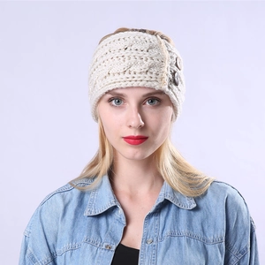 Close-up of cable knit winter headband in cream with three wooden decorative buttons