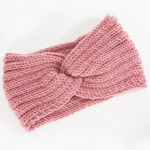 Détail d'un bandeau en maille rose avec nœud croisé et texture épaisse torsadée