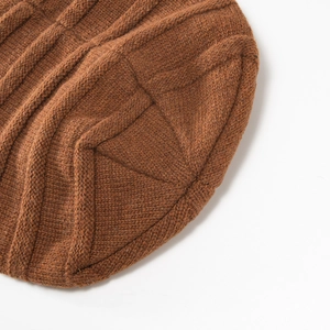 Nahaufnahme der karamellbraunen Strickmütze mit Zopfmuster und feiner Wolltextur im Detail