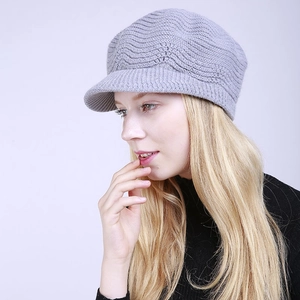 Detail of light purple knitted newsboy cap featuring textured wavy patterns and soft wool
