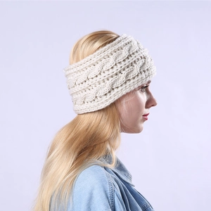 Side view of model wearing a thick cream-white cable knit headband with button detail