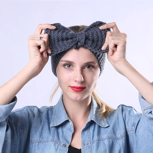 Dettaglio della fascia in maglia grigio scuro per donna con fiocco e trama spessa