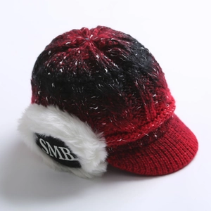Detail of red and black knit winter hat with white faux fur earflaps and SMB logo