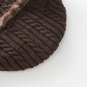 Detail of cable knit texture and warm brown faux fur lining on a thick winter beanie