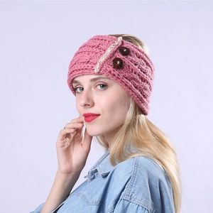 Detailed knit texture of pink cable headband with lace trim and decorative buttons