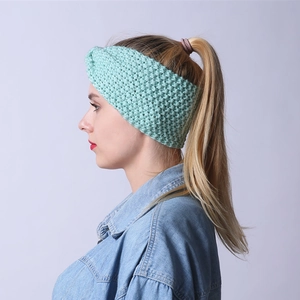Seitenansicht einer Frau mit handgestricktem mintgrünem Stirnband mit Knotendesign