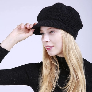 Detail of black knitted newsboy cap featuring elegant wave texture and short brim for women