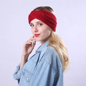 Close-up of bright red knitted twisted headband showing thick wool texture and detail