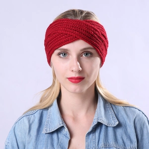Close-up of a red knitted crossover headband with thick striped woven texture on a model
