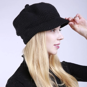 Side view of black knitted newsboy cap with wool texture and decorative top button