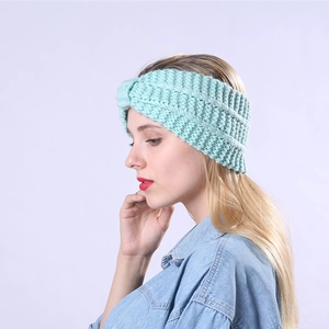 Detailed close-up of mint green knitted headband featuring a stylish twist knot design