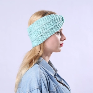 Close-up of mint green knitted headband showing thick ribbed texture and twist knot