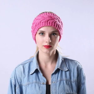 Detalle de diadema de punto rosa con textura de trenza gruesa usada por una modelo