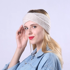 Detail of cross-knot design on beige knitted headband showing soft warm texture