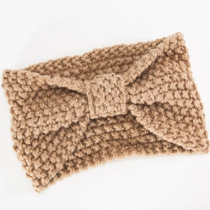 Detailaufnahme der groben Strickstruktur und des Knotens am hellbraunen Winterstirnband