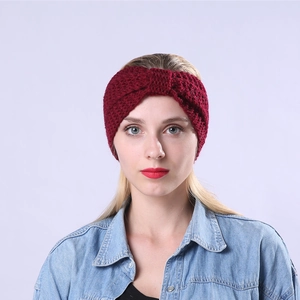 Detail of burgundy thick knit headband featuring a crossover knot for winter warmth