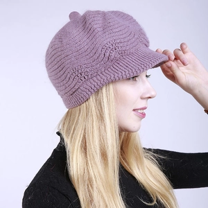 Detail of light purple knitted beret with textured wave patterns and small peak brim