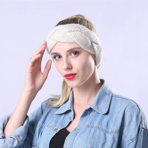 Close-up of cream cable knit headband showing thick braided wool texture and warmth