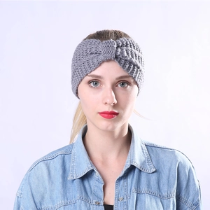 Close-up of grey knitted headband with twist knot detail on female model forehead