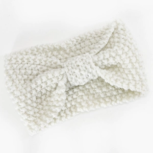 Nahaufnahme des cremefarbenen Strickstirnbandes mit grobem Muster und Schleifendetail