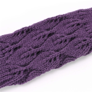 Dettaglio macro della maglia a treccia e traforata viola scuro sui guanti invernali