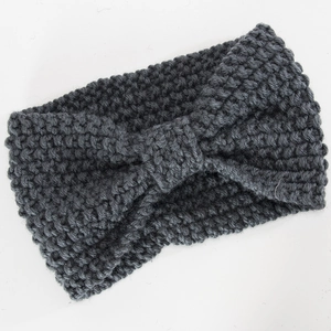 Detailaufnahme eines dunkelgrauen Strickstirnbandes mit grober Textur und Schleife