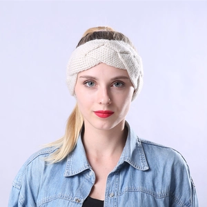 Close-up detail of cream cable knit headband showing thick braided yarn texture