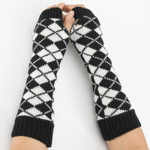 Détail de mitaines en tricot à motif de losanges noirs et blancs avec trou pour pouce