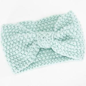 Detail der Strickstruktur eines minzgrünen Stirnbandes mit zentralem Knotendesign