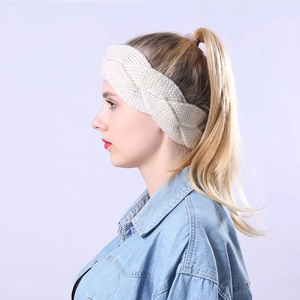 Detail of cable knit headband in cream white showing thick texture on a female model