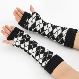 Détail de mitaines longues tricotées avec motif argyle noir et blanc et poignets à bord-côte