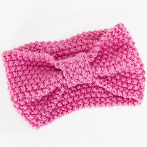 Nahaufnahme des rosaroten Strickstirnbands mit dicker Garnstruktur und Schleife