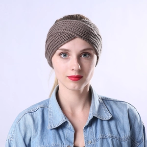 Detail shot of a dark brown knitted criss-cross headband on a fashion model