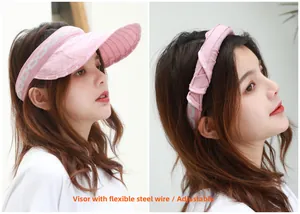 Dettaglio cappello parasole rosa pieghevole con tesa flessibile, usato come fascia
