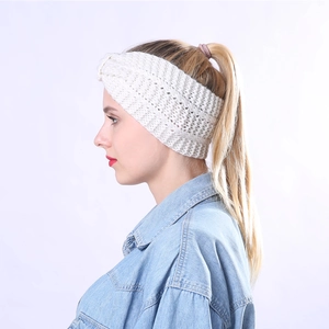 Detail of cream cable-knit headband with twist knot design for winter warmth
