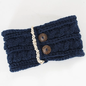 Detail of dark blue cable knit headband with cream lace trim and two wooden buttons
