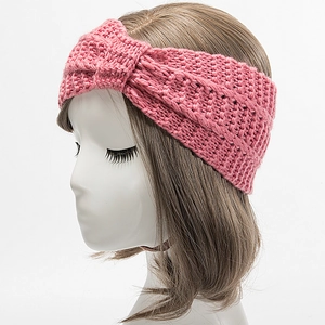 Detailed knit texture of pink winter headband with decorative twisted cross design