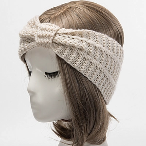 Close-up of cream knitted headband with a stylish twist knot on a mannequin head