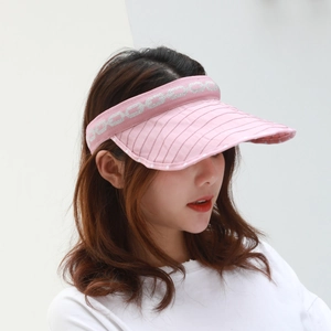 Detail of pink sun visor showing texture with white polka dots and woven chain pattern